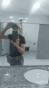a man taking a selfie in a public restroom