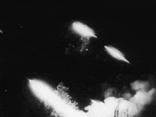 a black and white photo of a group of rockets being launched into the air .