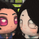 a close up of two stuffed dolls with a keyboard in the background