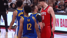 a group of basketball players are standing on a court and one of them has the number 12 on his jersey