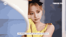 a woman in a yellow dress is looking at herself in a mirror with twice tv written on the bottom