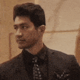 a man in a suit and tie is standing next to another man .