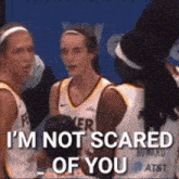 a group of female basketball players are talking to each other and one of them says " i m not scared of you "