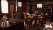 a man sits at a table in a room with the words heart & home on the bottom