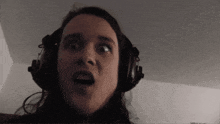 a woman is wearing headphones and making a funny face