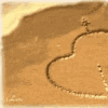 a heart drawn in the sand on a beach .