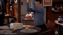 a man is sitting at a table with a bowl of fruit .