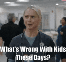 a nurse with a stethoscope around her neck is standing in a hospital hallway .
