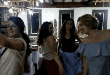 a group of young women are dancing together in a room