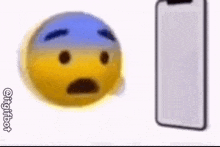 a yellow and blue smiley face is standing next to a cell phone .