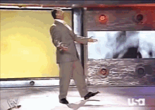 a man in a suit and tie is dancing on a stage in front of a wall that says usa on it