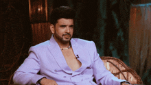 a man in a purple suit is sitting on a couch