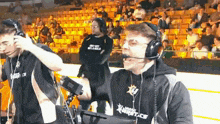 a man wearing headphones and a shirt that says xtreme ice is talking into a microphone .