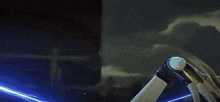 a person is holding a sword in their hand with a blue light coming out of it .