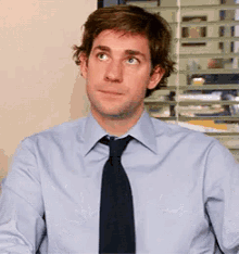 a man wearing a light blue shirt and black tie
