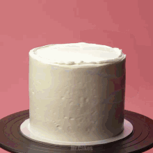 a cake with white frosting sits on a black plate that says mr.cakes on the bottom