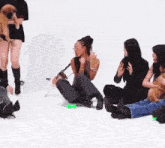 a group of women are sitting on the floor with their feet up and a dog .