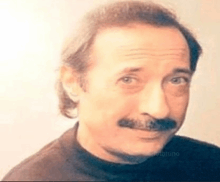 a close up of a man with a mustache wearing a black shirt .