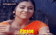 a woman in a red sari is making a funny face while holding a piece of food .