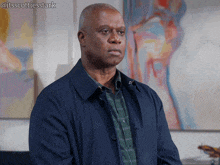 a man in a blue jacket is standing in front of a painting with the hashtag itsscottiesstark