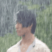 a man is standing in the rain looking at something .
