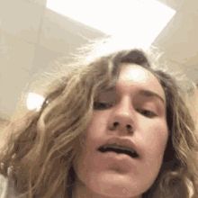 a woman with long blonde hair is making a funny face .