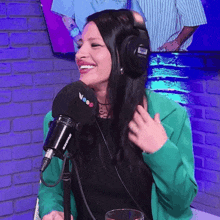 a woman wearing headphones and a shure microphone is smiling