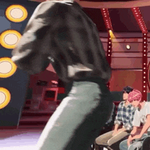 a man in a black shirt is dancing in front of a group of people