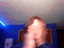 a blurry picture of a person 's face with a blue wall in the background
