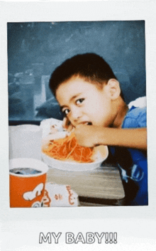 a picture of a young boy eating spaghetti with the words " my baby " below him