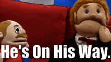 two puppet characters are sitting on a red couch with the words he 's on his way behind them