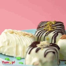 three desserts on a blue plate with yum up written on the bottom right