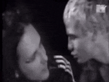 a man and a woman are standing next to each other in a black and white photo .