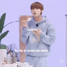 a man in pajamas is standing in front of a table with the words baila si eres de mon written on the bottom