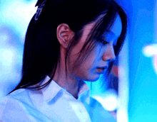 a close up of a woman 's face in front of a blue background