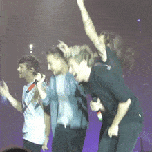 a group of men are standing on a stage with their hands in the air