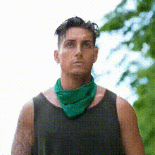 a man wearing a black tank top and a green bandana around his neck