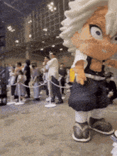 a mascot is standing in front of a crowd of people at a convention