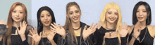 a group of girls are waving their hands in front of a white wall