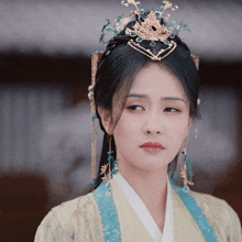a woman with a crown on her head looks at the camera with a sad look on her face