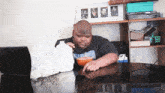 a man sitting at a table eating cereal and milk