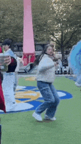 a woman is dancing on the grass in front of a crowd .