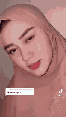 a close up of a woman wearing a hijab with a tiktok icon next to her
