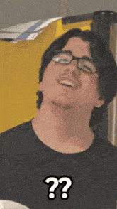 a man wearing glasses and a black shirt has a question mark above his head