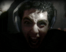 a man wearing headphones is making a very angry face