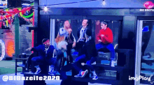 a group of people are dancing in front of a big brother logo