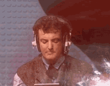 a man wearing headphones with his eyes closed looks down