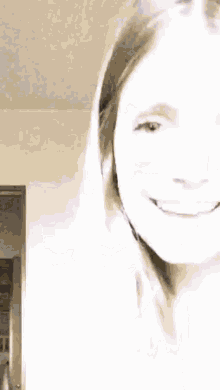a black and white photo of a woman smiling in front of a door .