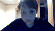 a young boy with a black shirt on looks at the camera