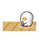 a duck is sitting on a wooden table .